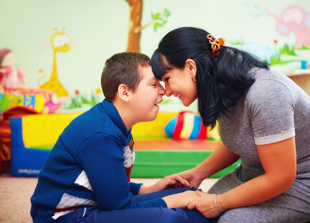 Soulful moment. Portrait of mother and her beloved son with disability in rehabilitation center