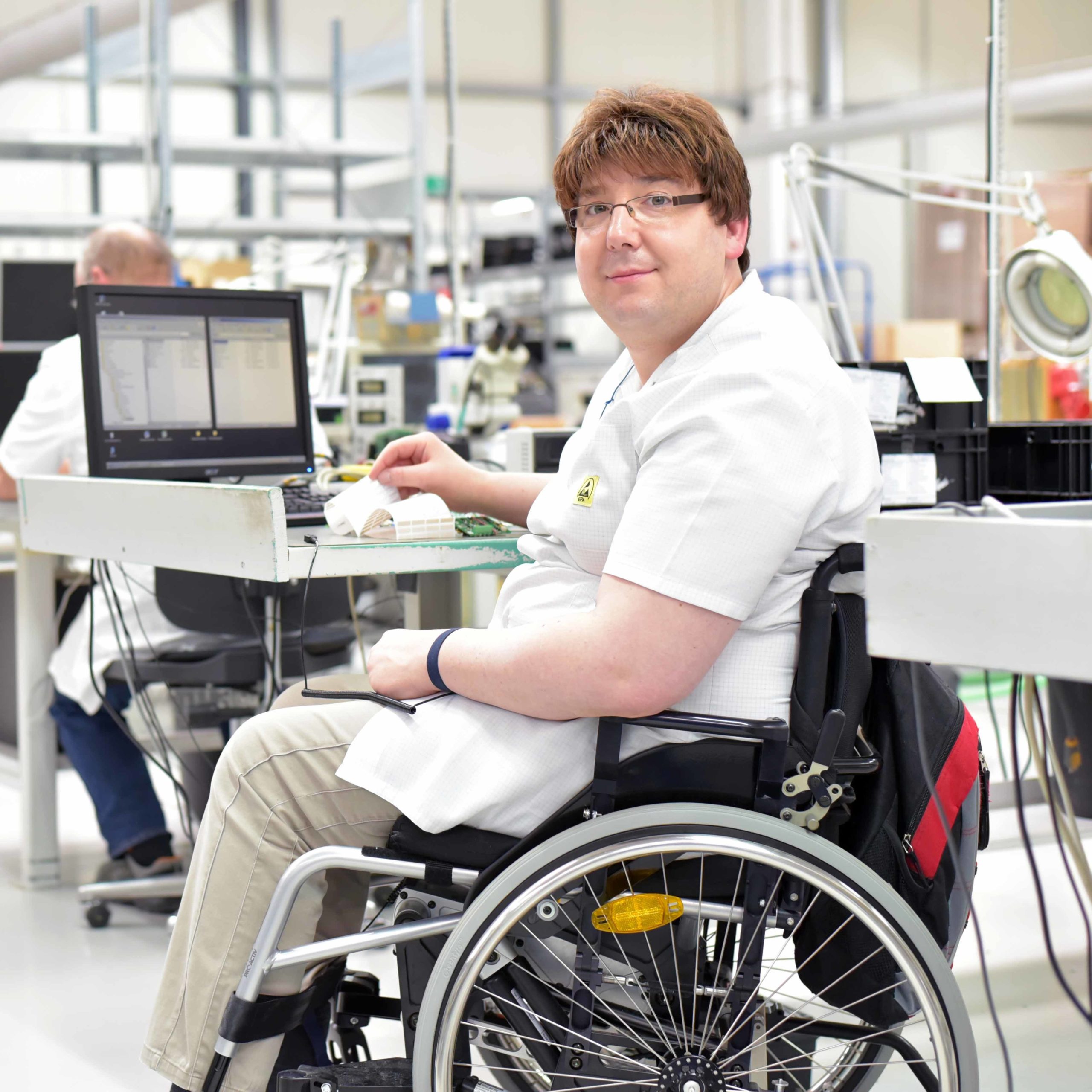 Man in wheelchair in an office setting using an Assistive Technology Computer.