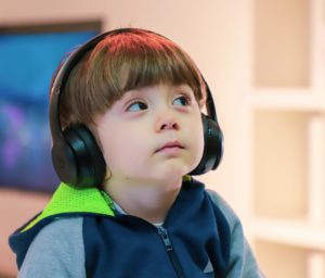 Child with a disability with assistive technology headphones.