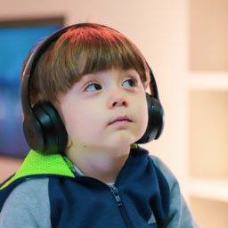 Child with a disability with assistive technology headphones.